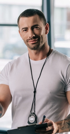 muscular guy in a white T-shirt with a timer on his neck