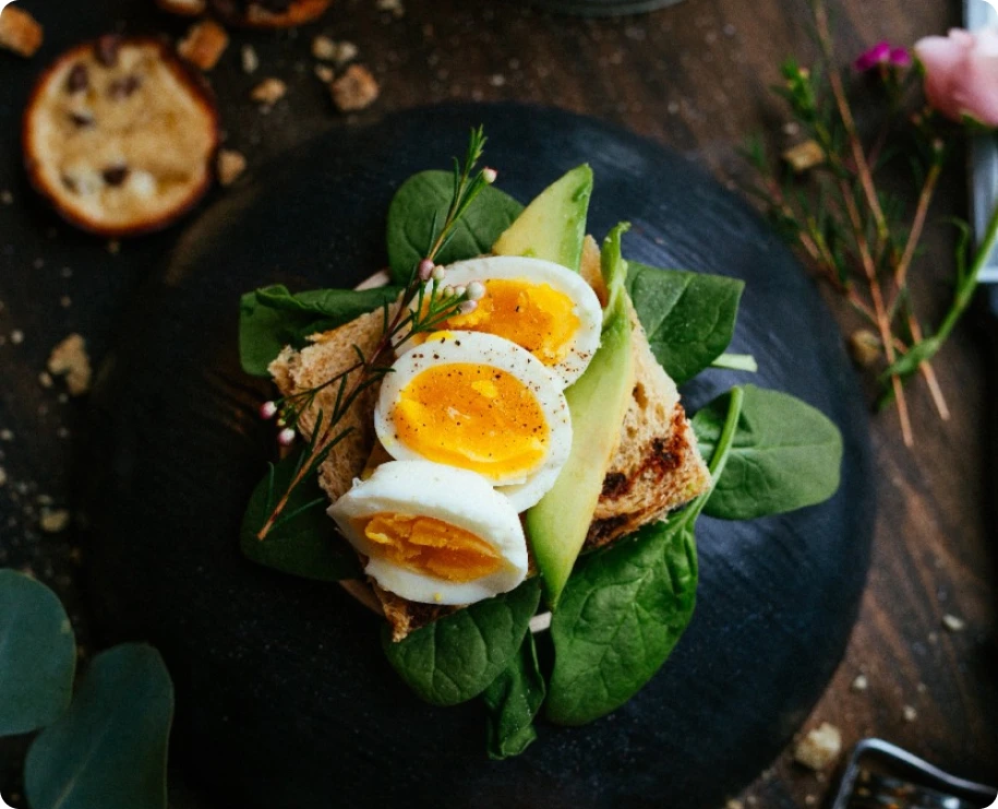 breakfast of eggs, vegetables and shortbread on a black plate