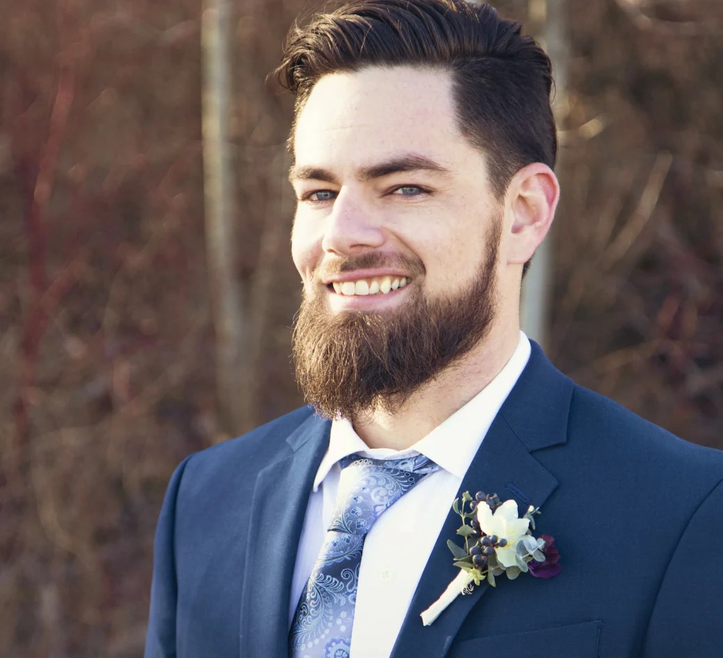 a groom with a beard in a suit