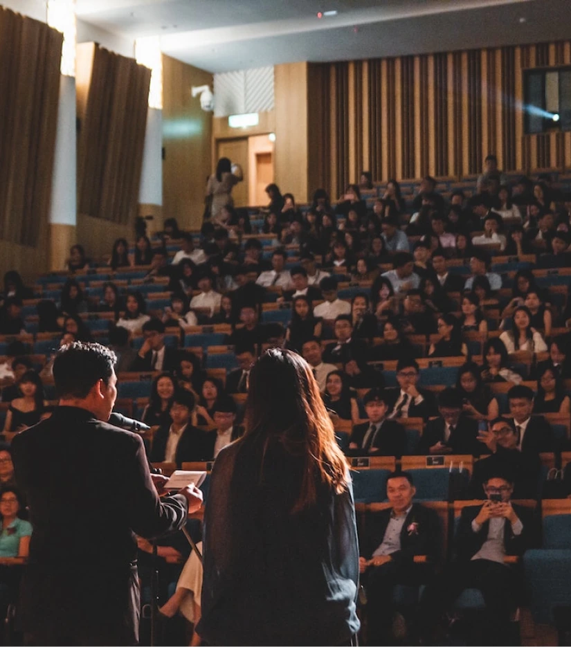 two people at a microphone in front of an audience