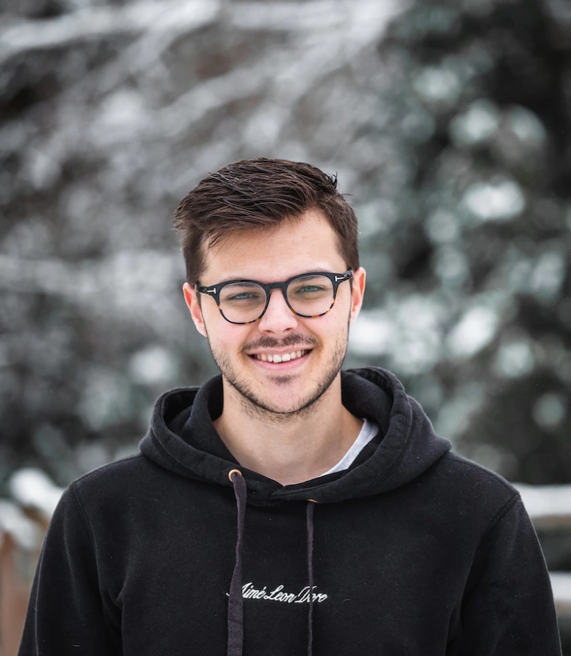 young guy with glasses and a smile on his face