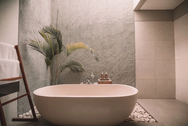 stylish bathroom in light colors with a plant in the corner