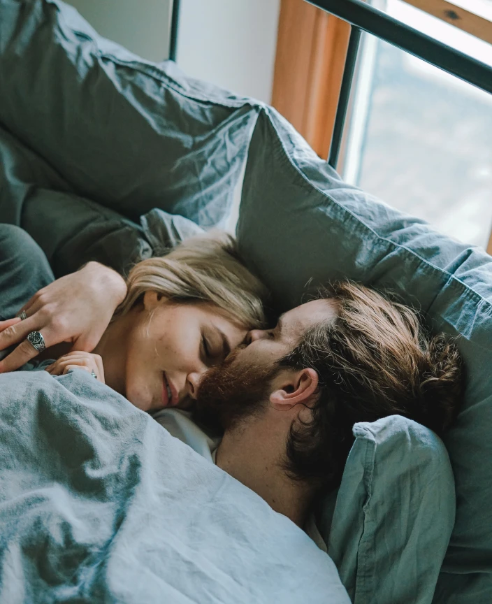 the bride and groom are lying in bed