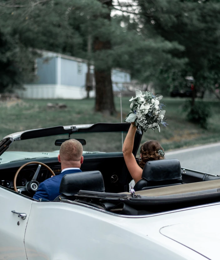 the bride and groom are traveling by car