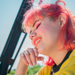 a girl with pinkish hair smiles