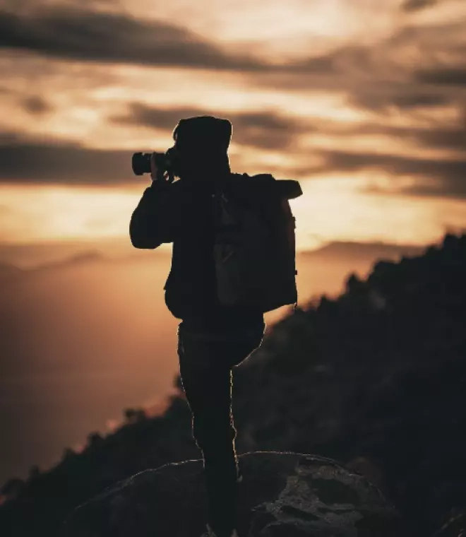 A man takes a picture of a sunset