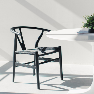 silla negra y mesa blanca en una habitación luminosa