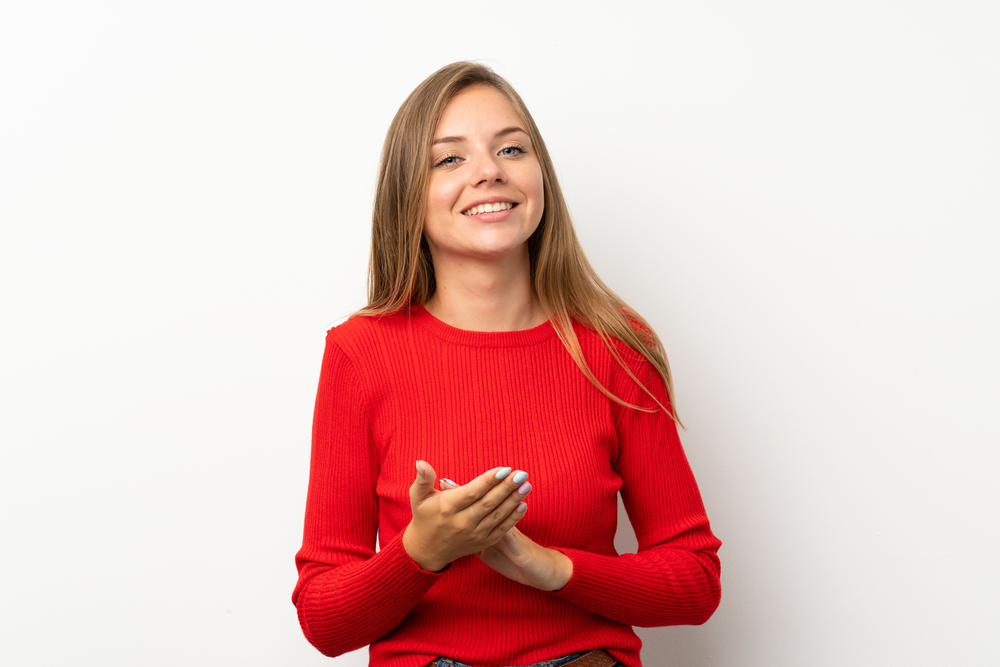 a girl in bright red clothes and long blond hair, folded her hands in front of her