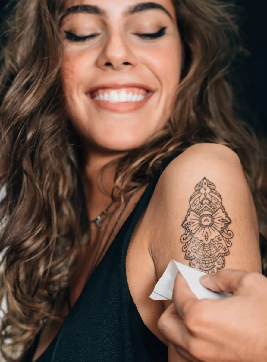 Uma garota faz uma tatuagem
