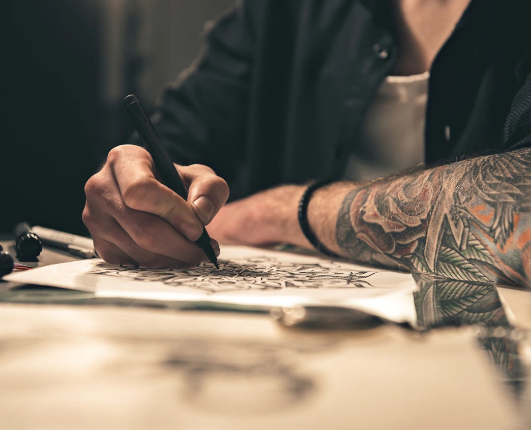 el artista dibuja un tatuaje en papel