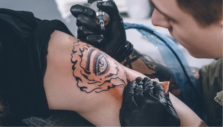 the tattoo artist makes a tattoo on the arm