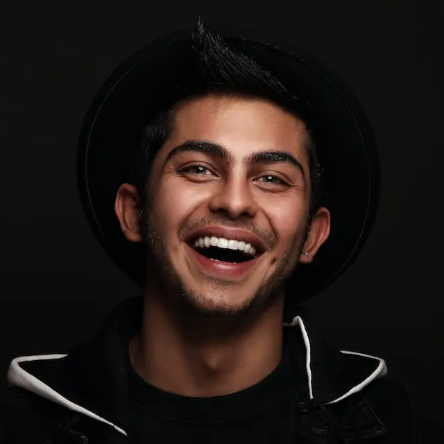 smiling guy in dark clothes and hat