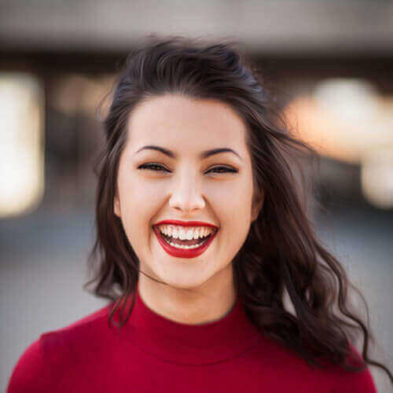 A girl with dark hair in red clothes laughs