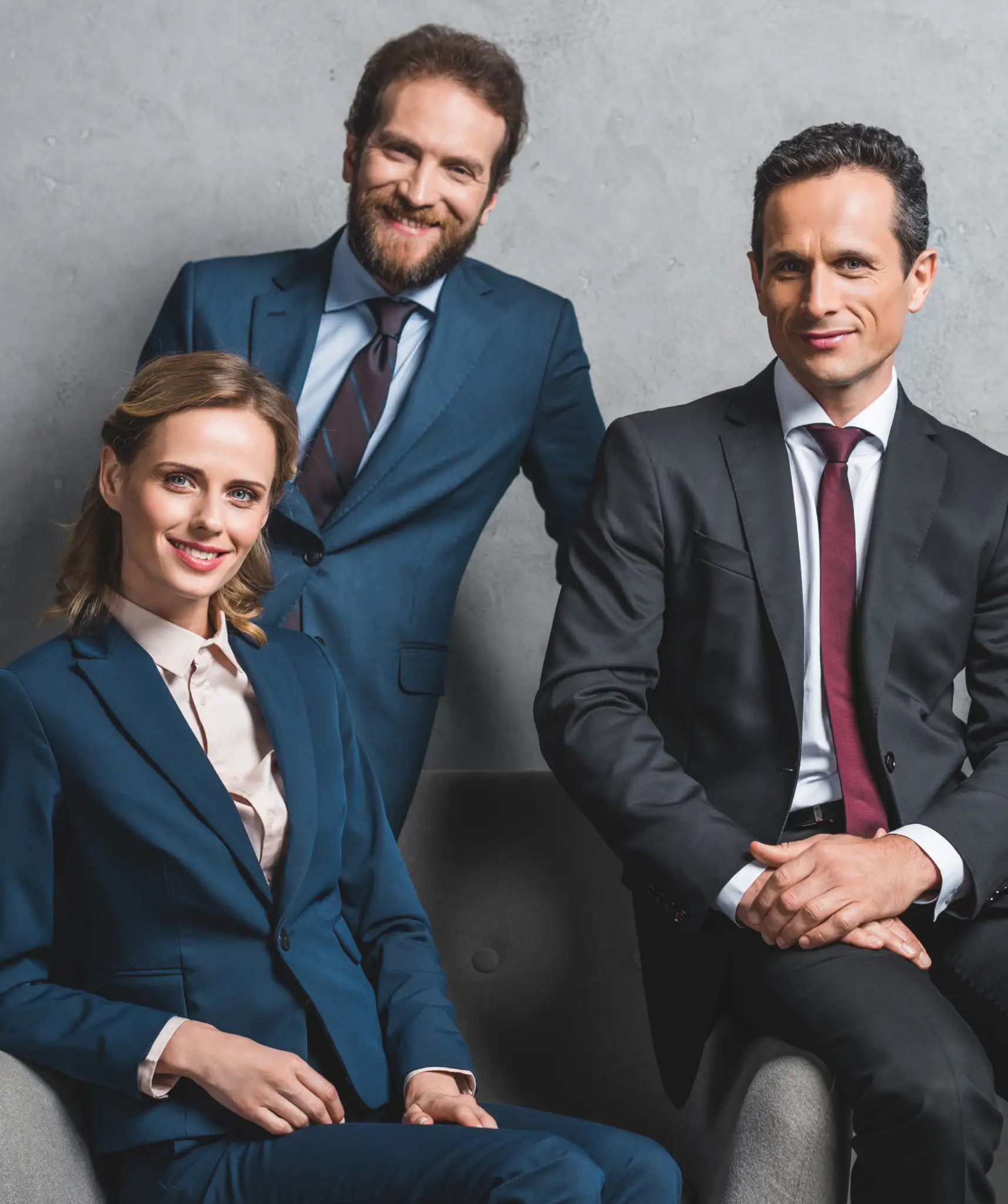 Two guys and a girl in formal dark green and black suits