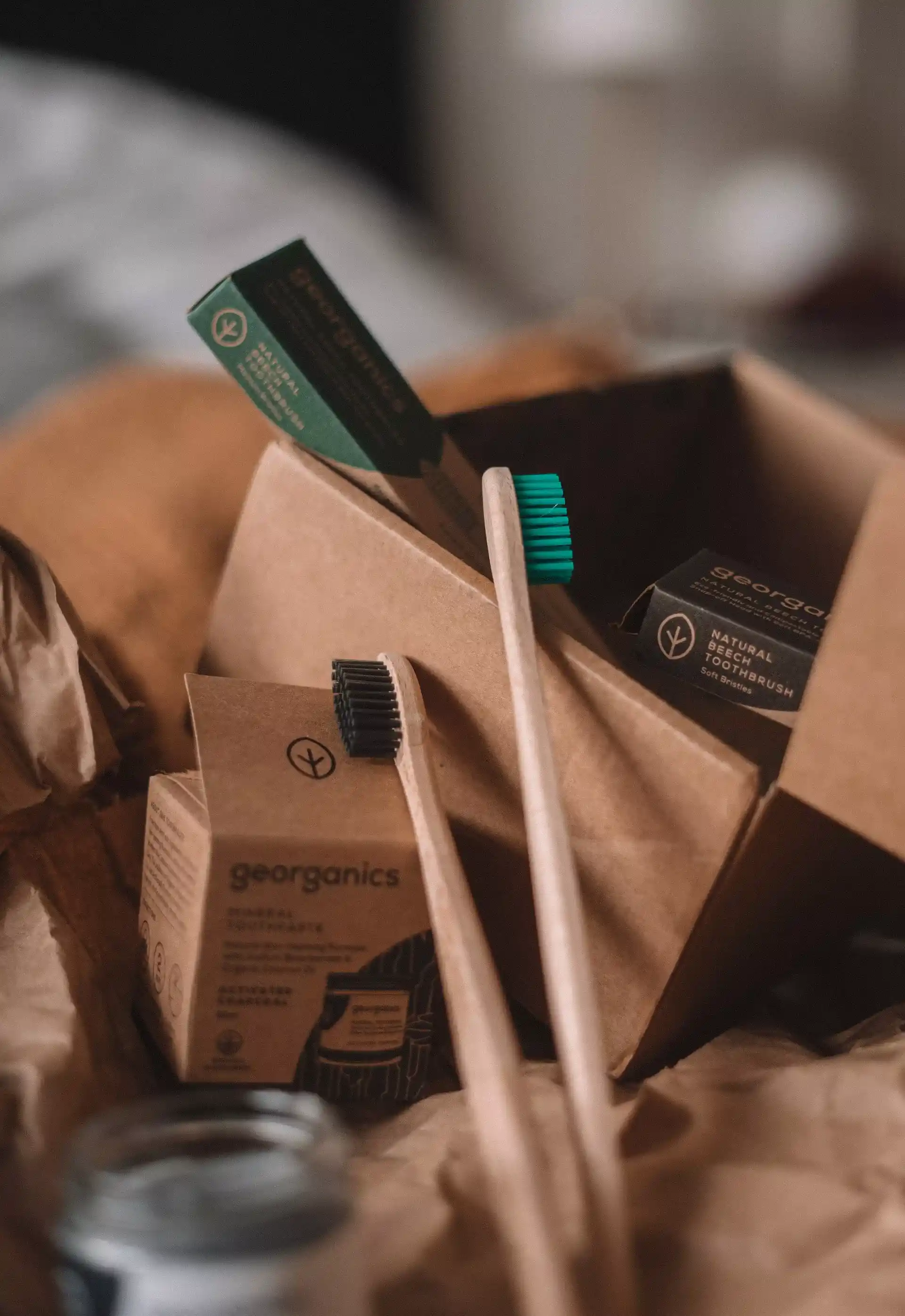 two wooden toothbrushes, with black and turquoise fibers