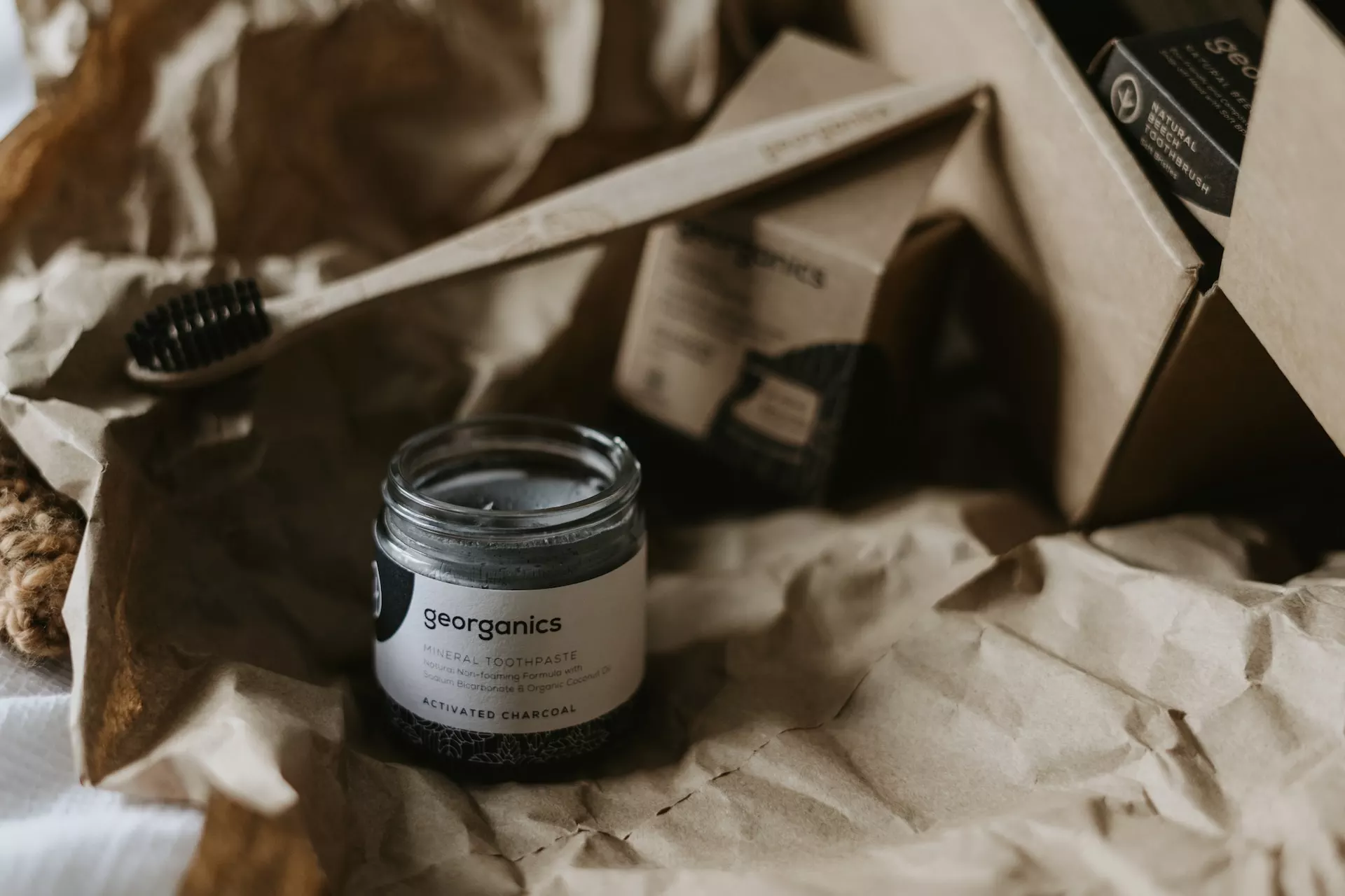 wooden toothbrush with a jar of dark product