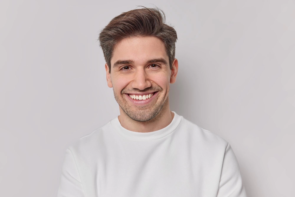 A man with gray hair smiles widely