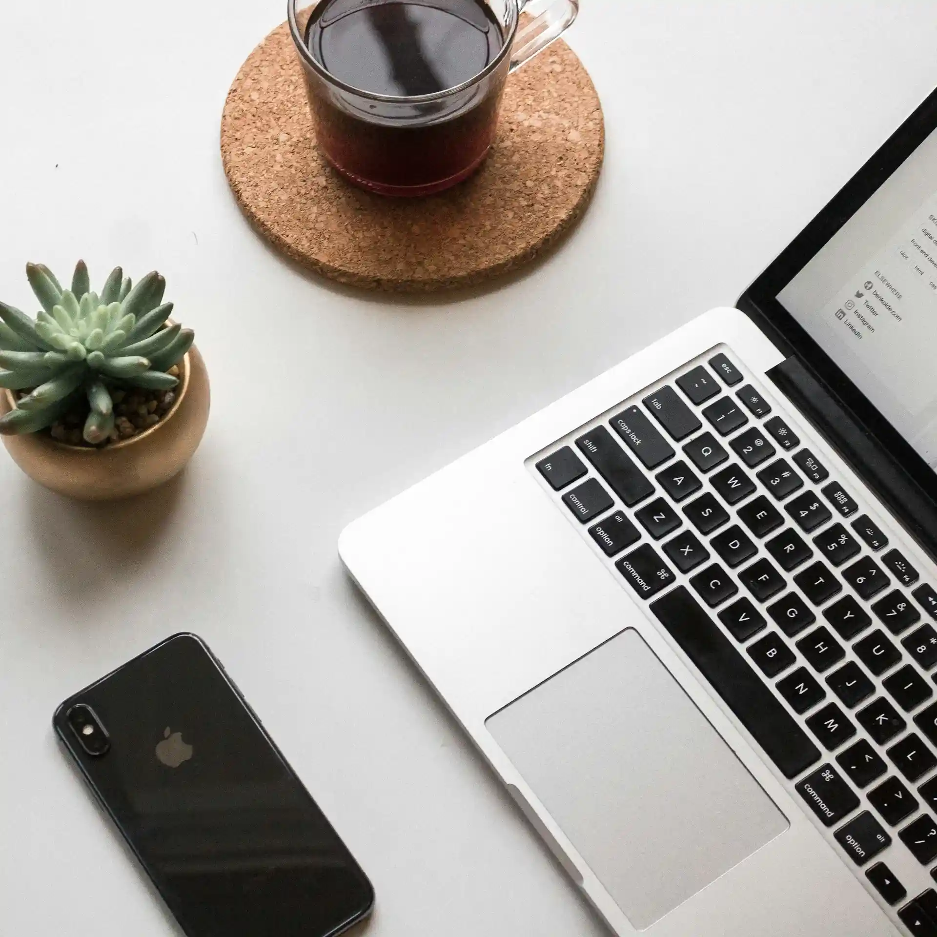 Workplace with laptop, flower, smartphone and cup of tea