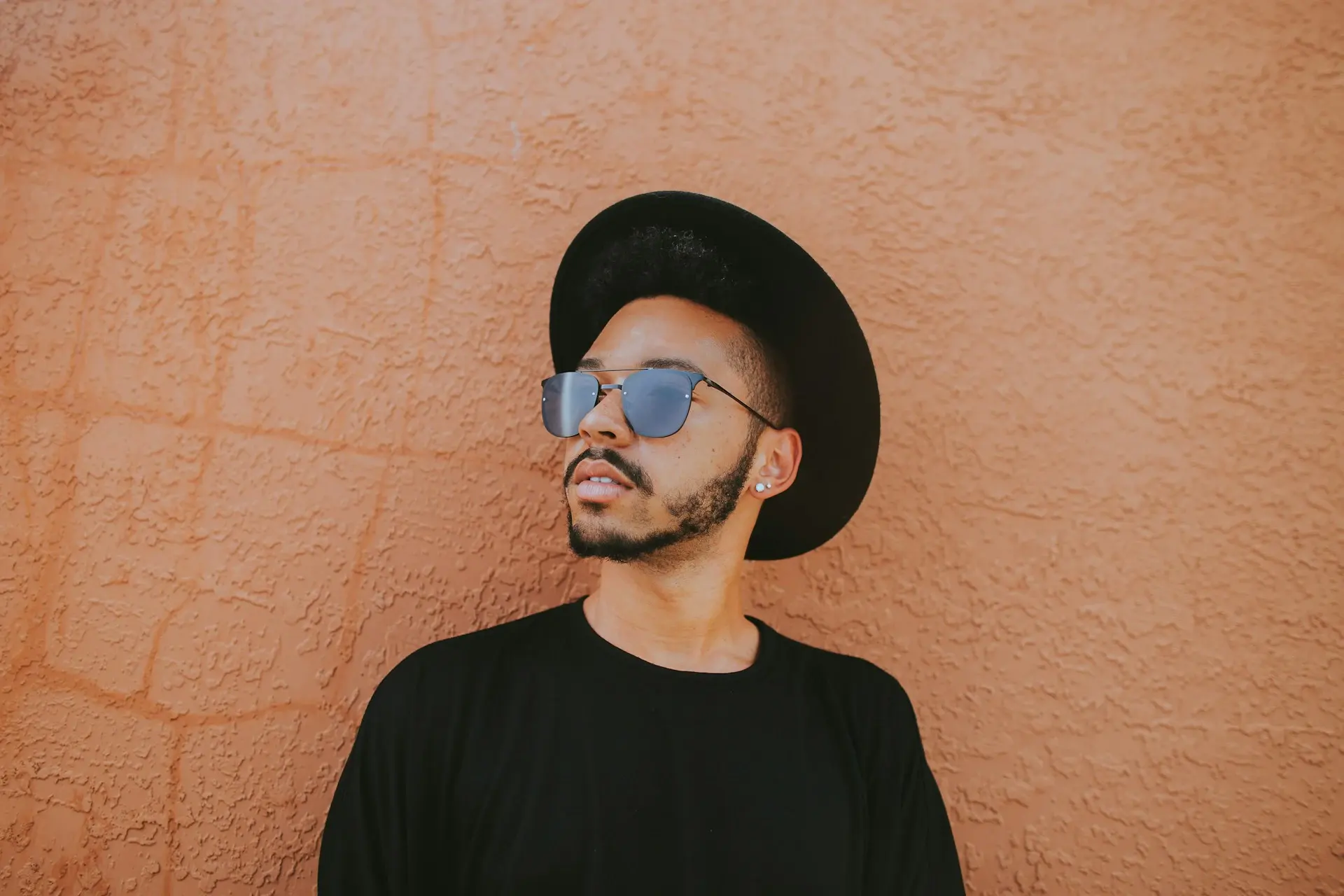 A young guy in glasses and a black hat with a shield on his face