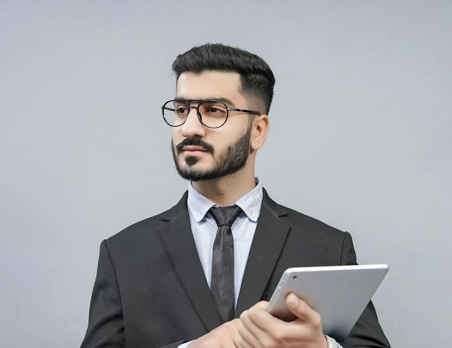 A young guy in glasses and a formal suit with a beard looked to the side