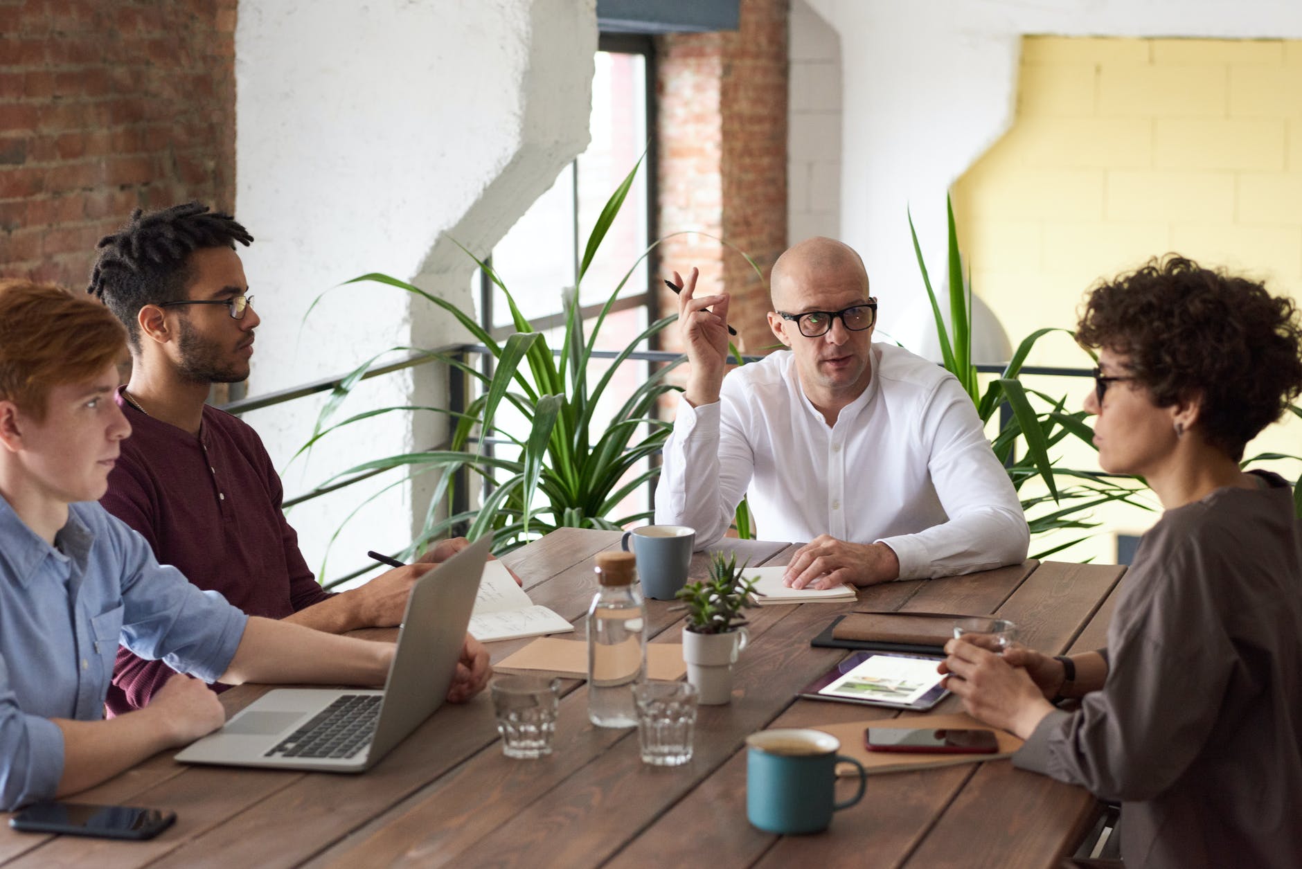 Four people are talking in office with team leader