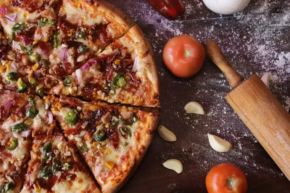 pizza and vegetables lying next to it