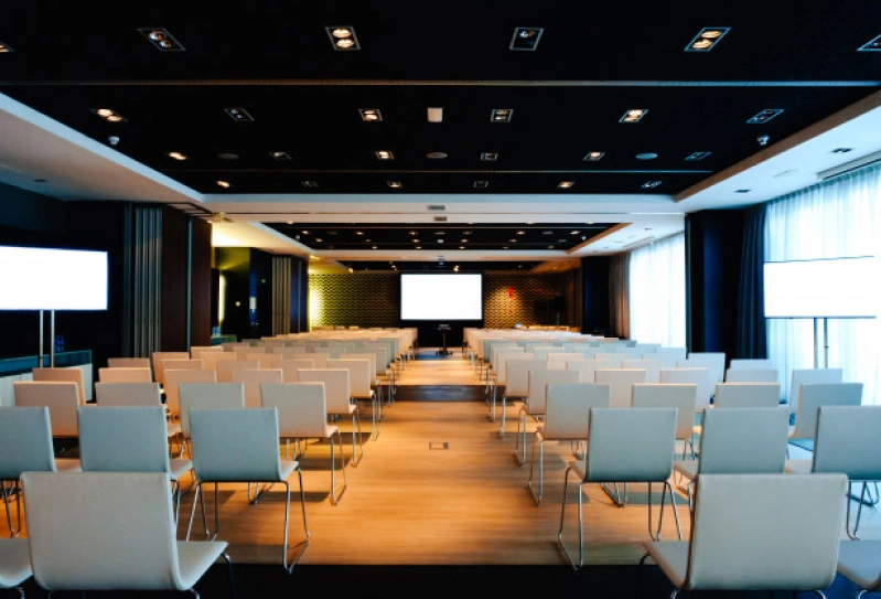 uma sala de conferências sem participantes e com uma boa iluminação nas janelas